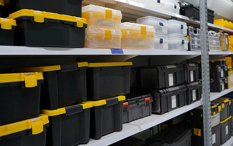 Plastic storage boxes organised on shelves inside a business storage unit
